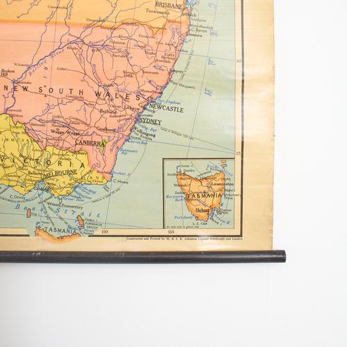 A vintage school pull down wall map of australia. The map has a wooden hanging pole at the top and bottom. The map is...