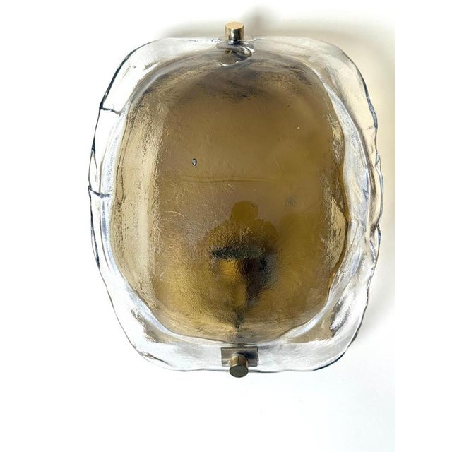 A beautiful vintage wall light by kaiser leuchten, germany, circa 1970s, featuring a heavy textured glass shade in a...