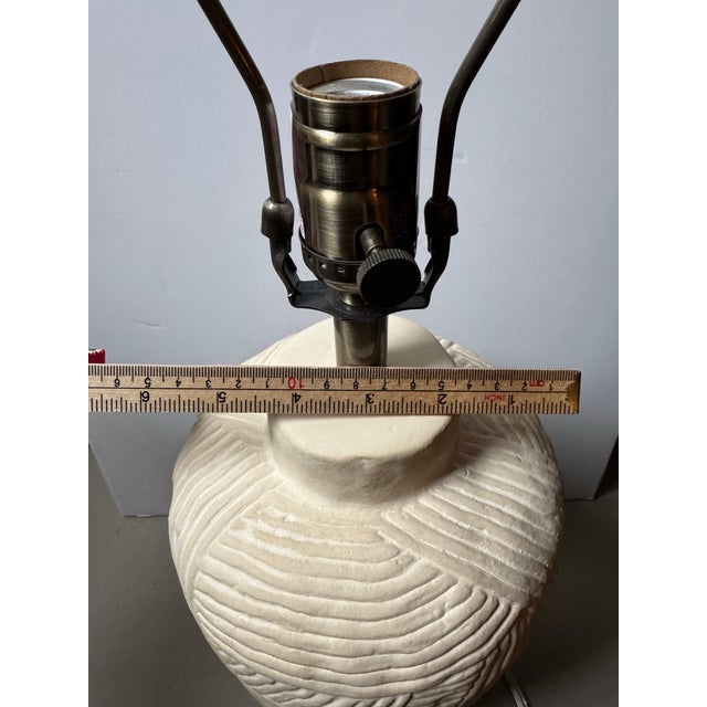 A handsome matched pair of Pottery Barn ceramic table lamps with heavily textured, incised ivory bases and an organic...