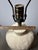 A handsome matched pair of Pottery Barn ceramic table lamps with heavily textured, incised ivory bases and an organic...