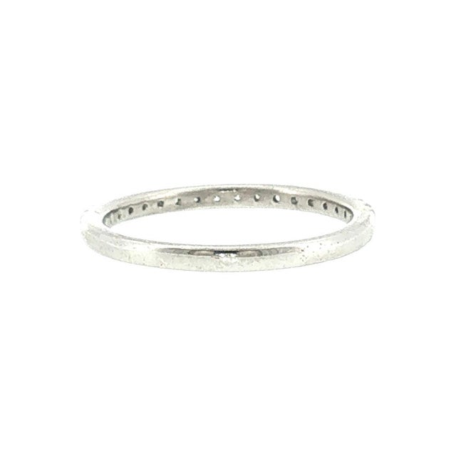 A 21st-century platinum split-prong set wedding ring featuring a row of brilliant-cut diamonds. The 18 diamonds weigh...