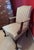 The vintage armchair features classic Queen Anne styling characterized by its elegant scroll armrests and dark wooden...