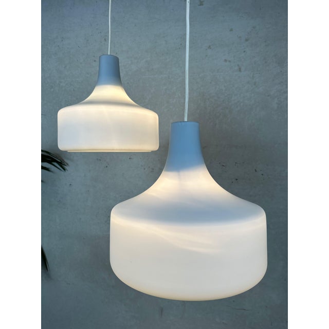 Two vintage opaline pendant lamps. Pastel blue. Attractive shape. In good condition. One has a small, inconspicuous chip...