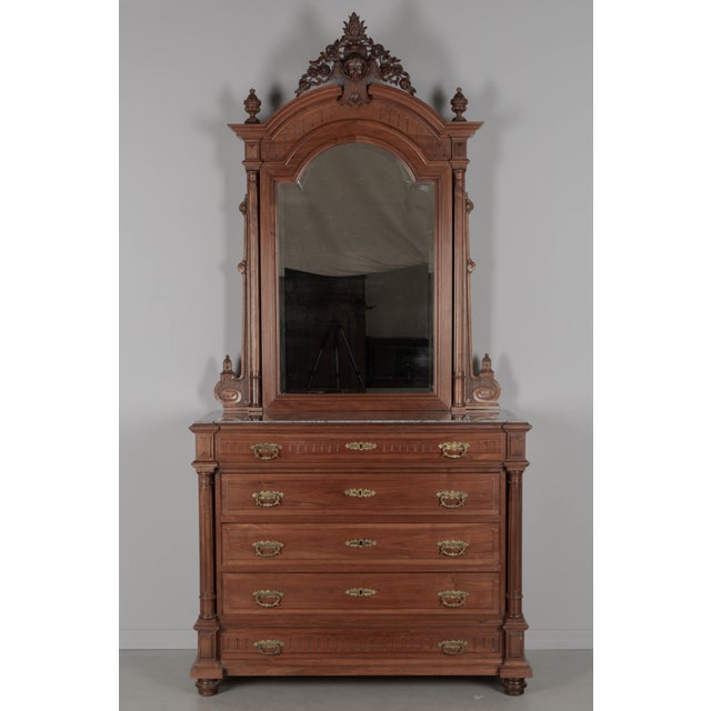 A grand Italian Renaissance Revival dresser and mirror made of solid walnut with architectural details including turned...