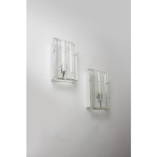 Pair of wall sconces with a white-painted metal frame and chrome-plated metal parts. Diffusers made of molded glass in the...