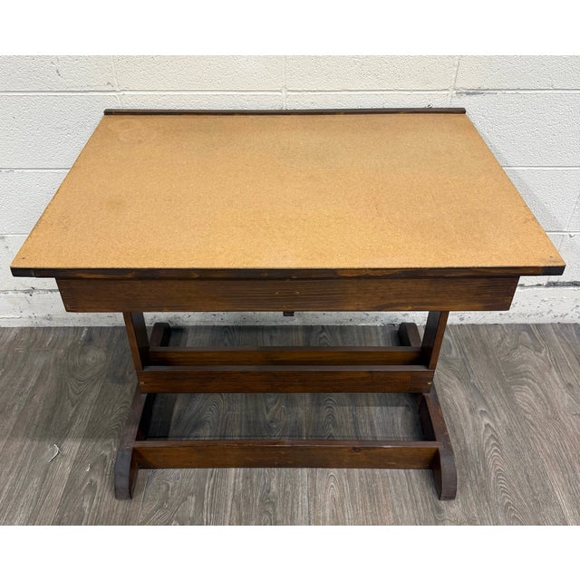 This is a vintage architect’s drafting table featuring a large adjustable work surface, brass angle-control hardware, an...