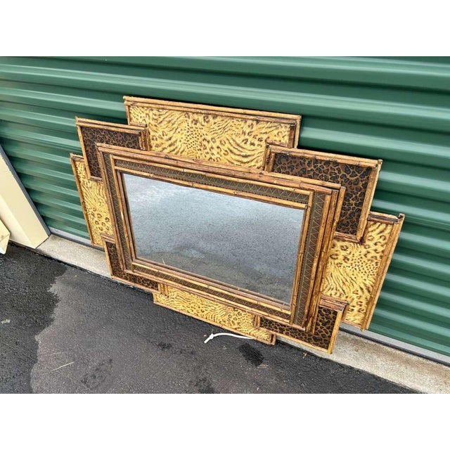Decorative wall mirror made circa 1970s in the Hollywood Regency style, featuring a layered geometric frame with faux...