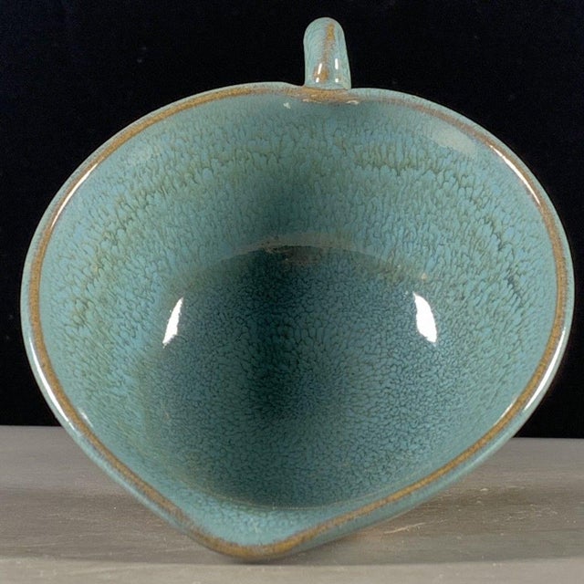 A charming small Chinese ceramic pouring bowl or cup. The vessel features a flared rim, a small pouring spout, and a...