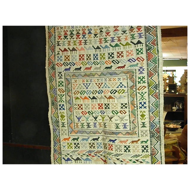 Full of colorful llamas, foxes, cats, birds, and numerous geometric figures, this 58 x 38 hand-woven wool wall hanging...