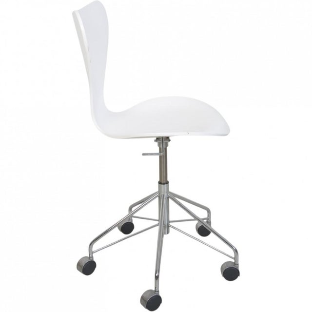 Arne Jacobsen office chair model 3117, with a white lacquered wood seat and a chrome frame. The chair is from 2008 and...