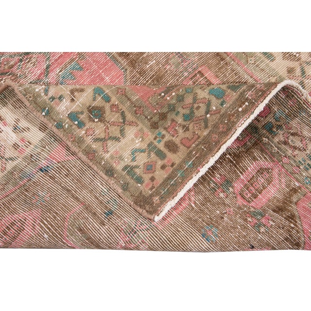 Beautiful vintage Azeri hand-knotted wool runner with a tan field. This rug has pink, sky blue, and beige accents in an...