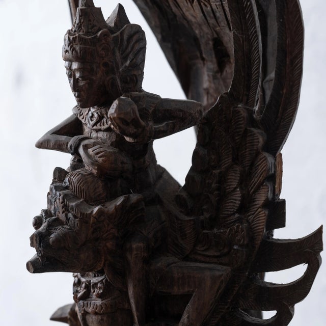 An Indonesian wood carving depicting Vishnu Garuda on Naga, circa 1920s. 8 ½ inches wide by 5 ½ inches deep by 16 ½ inches...