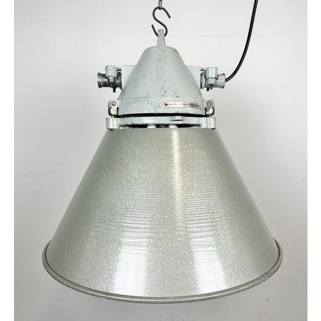 Industrial factory light manufactured by Elektrosvit in former Czechoslovakia during the 1970s. It features a cast...