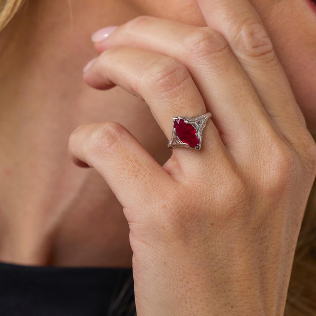 This exceptional Late Art Deco engagement ring is a beautifully distinctive jewel from the 1930’s, centered by a GIA-...