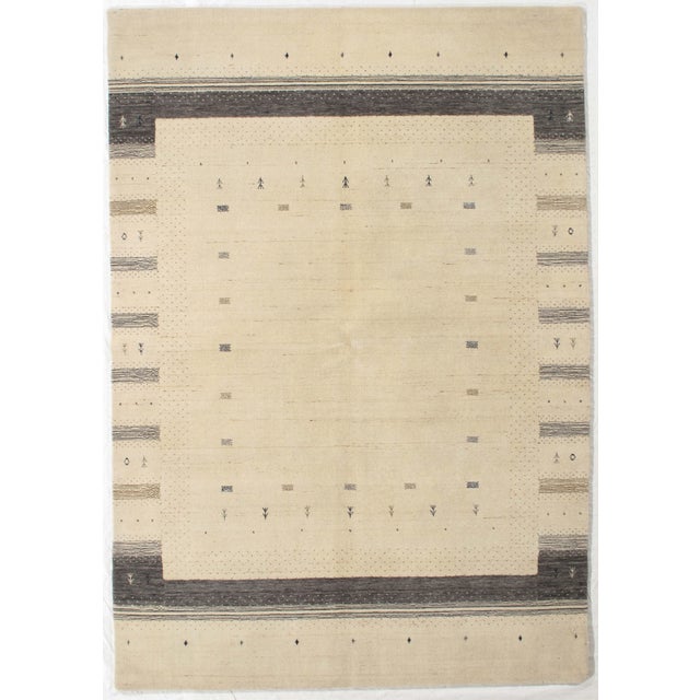 Vintage Hand-knotted Gabbeh rug featuring a soft, minimalistic field framed by subtle geometric borders. The design...