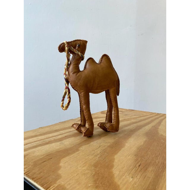 Vintage Hand-Stitched Leather Camel Soft Sculpture, Circa 1950s. Tan leather body rendered as a simplified camel, stuffed...