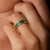 This striking Mid Century ring showcases a vibrant arrangement of eight square cut emeralds, together totaling...