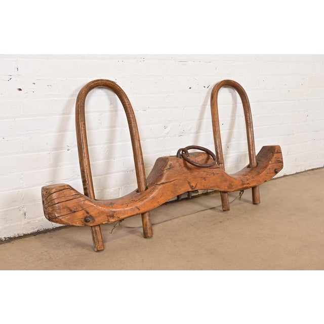 A rustic antique wooden ox yoke originally used as a working farm implement. Hand-carved from solid wood with original...