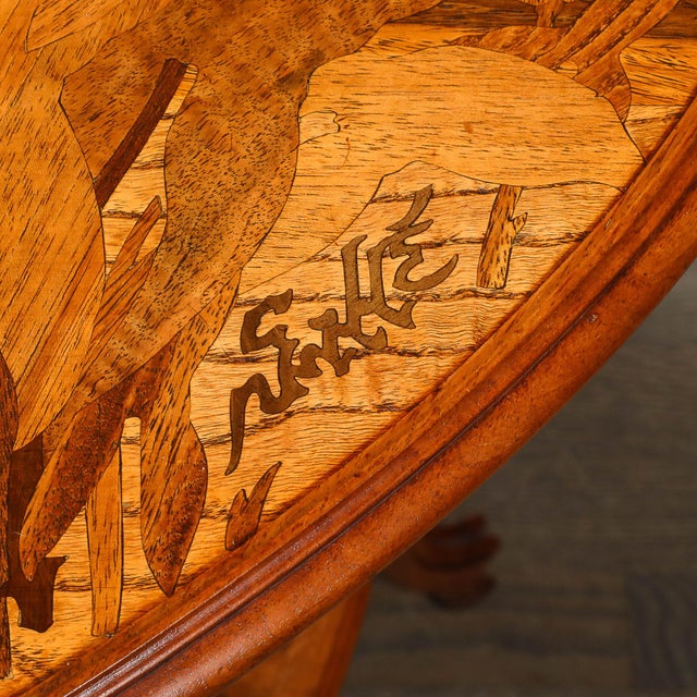 An exceptional Art Nouveau triangular two-tier side table, signed by the esteemed French designer Emile Gallé, featuring...