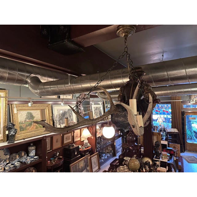 A striking and sculptural example of the traditional Lusterweibchen chandelier form, combining carved figural artistry...