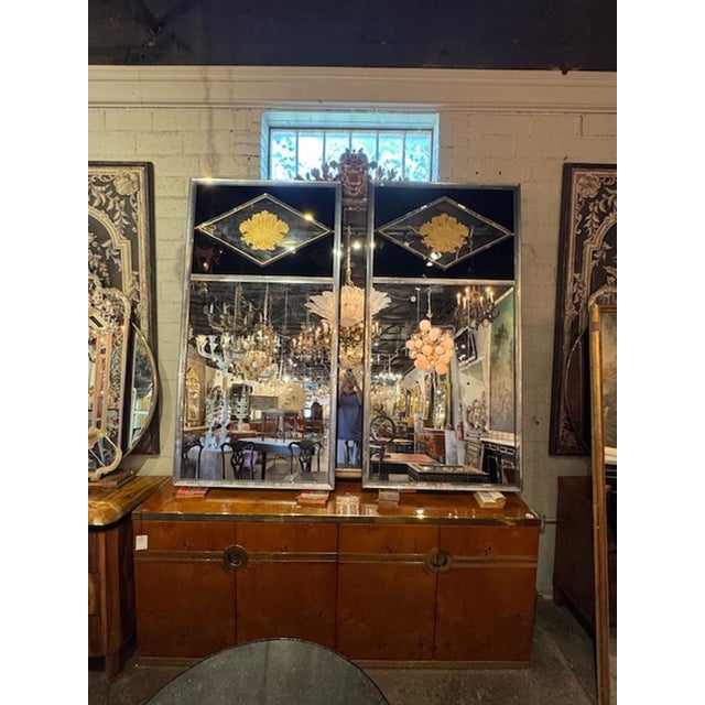 The product is a pair of Jansen Manner Eglomise Trumeau Mirrors, which are elegant and ornate mirrors designed to add a...