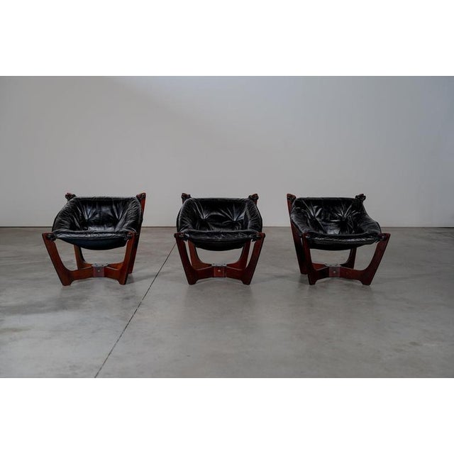 Luna lounge chairs in black leather. The chairs are in a good condition with some traces of usage normal to their age. w‍...