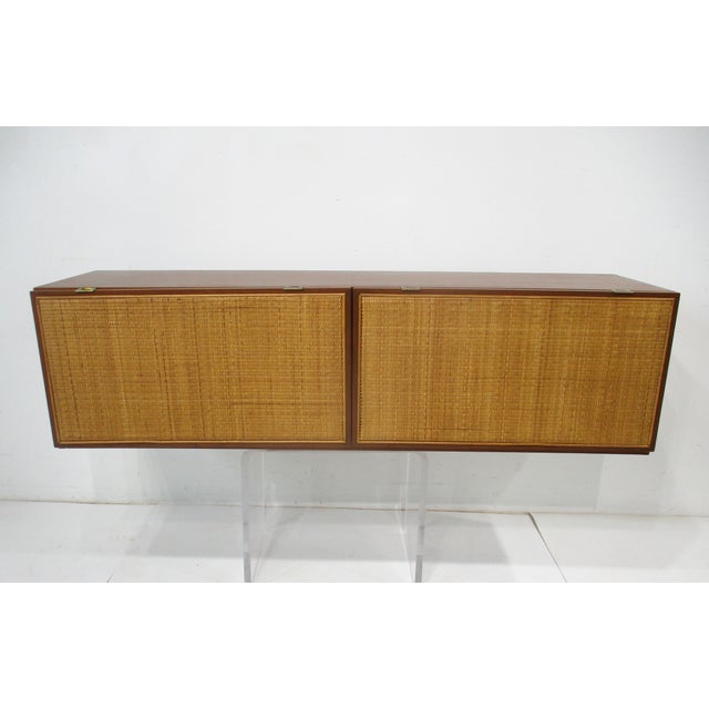 A walnut wall mounted cabinet with two doors and storage inside special ordered for a building in Columbus Indiana which...