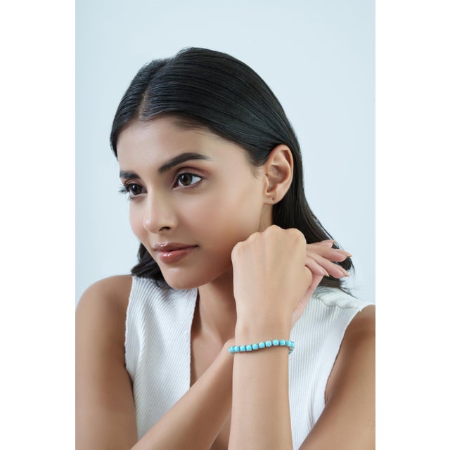 The Cushion-Cut 18.1 Ct Turquoise Tennis Bracelet features an elegant row of cushion-shaped turquoise gemstones set in...