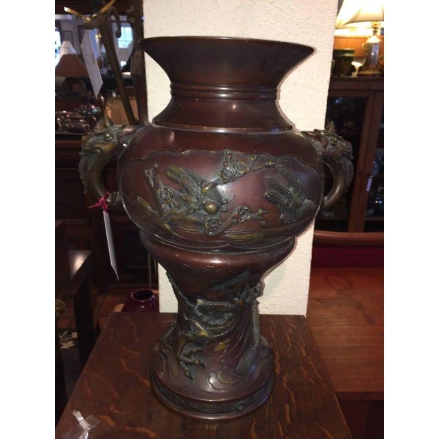 Large Meiji period bronze twin handled urn with decoration. Decoration consists of raised birds, branches with cherry...