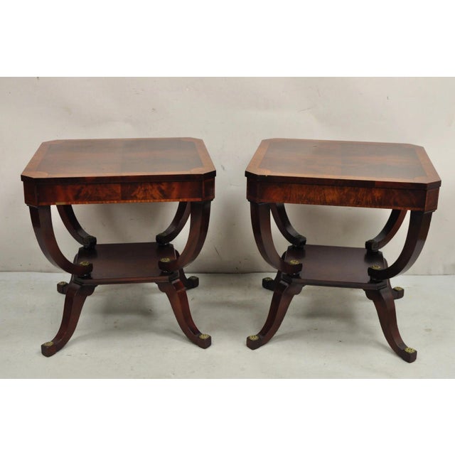 Vintage Regency Style Flamed Mahogany 2 Tier Square End Tables with brass medallions - a Pair. Circa Mid 20th Century....