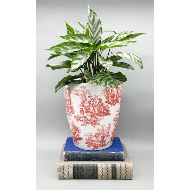 Gorgeous vintage ceramic cachepot featuring a classic red transferware pastoral scene on a crisp white ground. The...