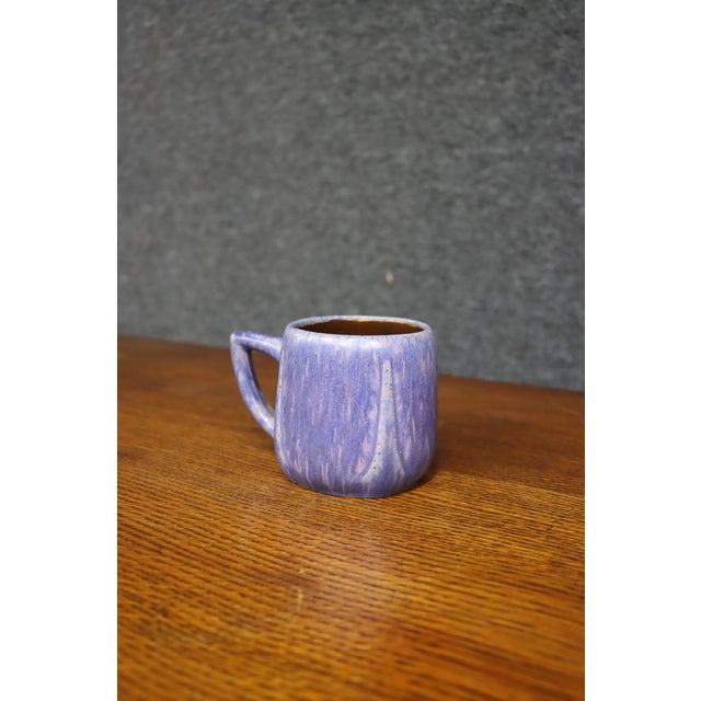 Early American art pottery mug attributed to Van Briggle, featuring a softly rounded cylindrical form with simple loop...
