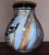 A striking fusion of Southwestern artistry and 1970s studio craftsmanship, this hand‑painted ceramic vase by Mapaw...