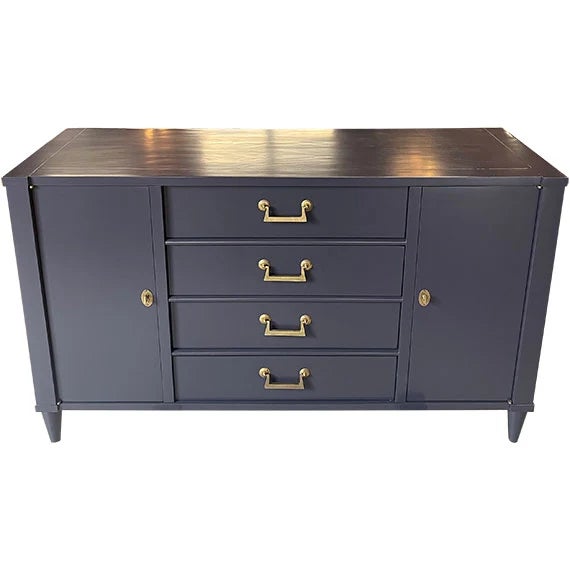 Vintage sideboard featuring a deep navy painted finish with warm brass hardware and a stained wood top. Four center...