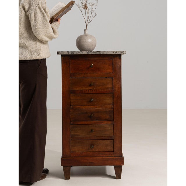This semainier chest carries genuine presence, its dark mahogany, marble top, 6 drawers immediately setting the tone for...