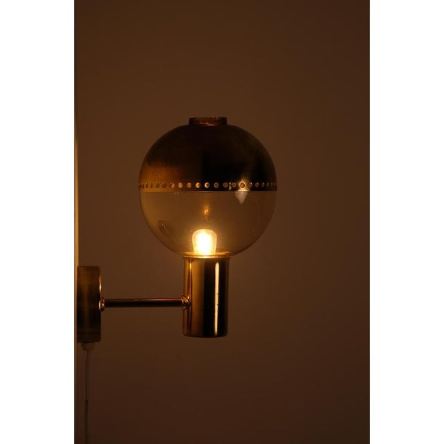 Pair of brass wall lights 'Patricia' with smoked glass and brass top, designed and produced by Hans-Agne Jakobsson,...