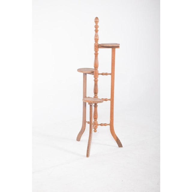 Flower box with circular supports for three pots. The structure is made up of three curved legs and turned reinforcements...