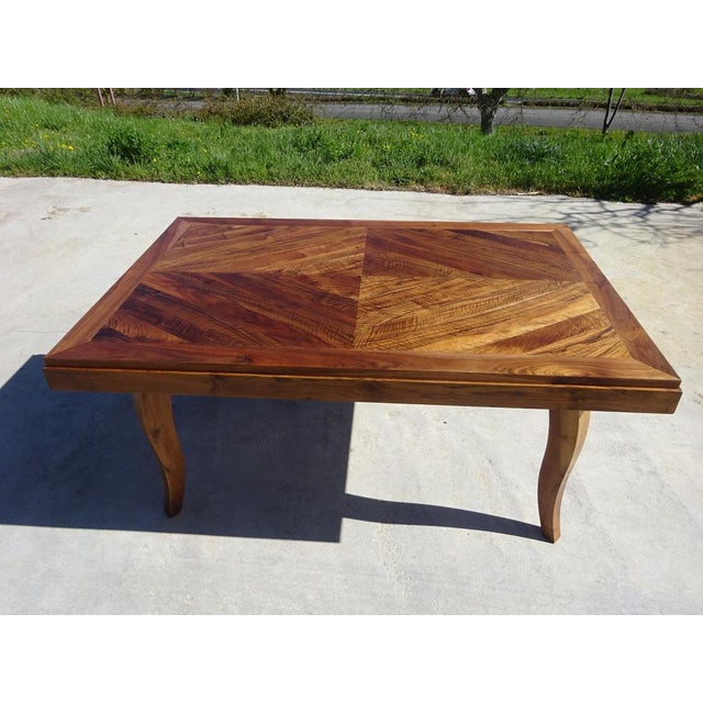 Vintage 1950s walnut table. Chevron marquetry top, solid walnut frame, legs, and apron. Sycamore sliding system supporting...