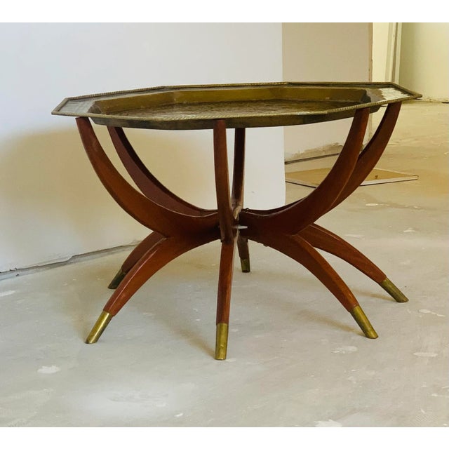 Vintage, Chinese, mahogany spider leg table with 6 legs with brass caps. The wooden base can be folded away for easy...