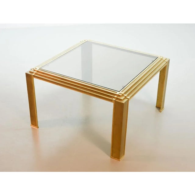 Solid brass square coffee table with smokey glass top. This very decorative coffee table is attributed to Peter Ghyczy and...