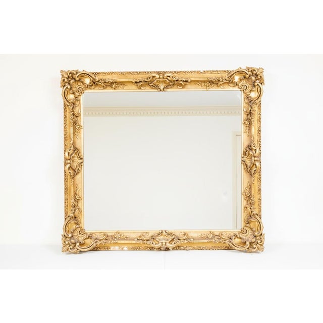 A stunning late Victorian Rococo Revival giltwood wall mirror, circa 1880–1900, featuring elaborate hand-carved scrolling...