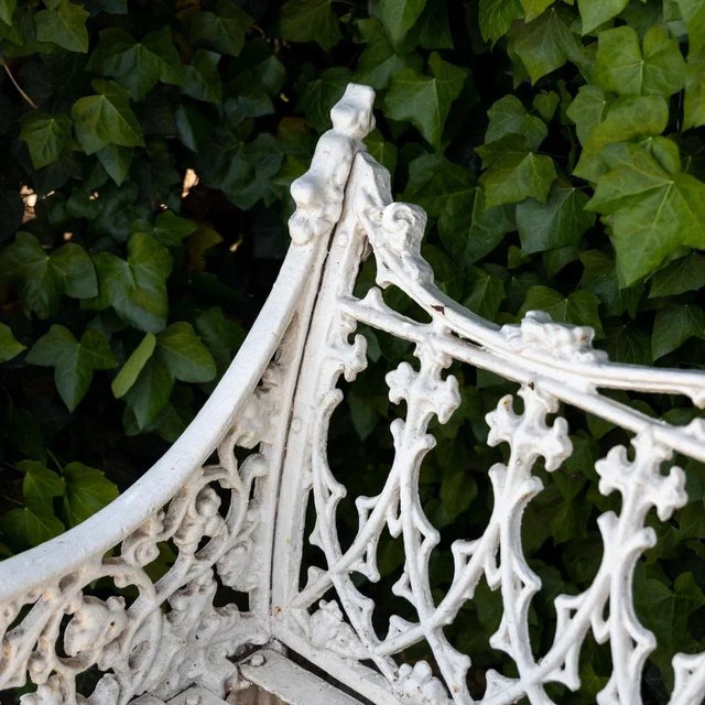 White lacquered cast iron garden bench in the neo-Gothic style of late 19th century Victorian garden furniture. The...