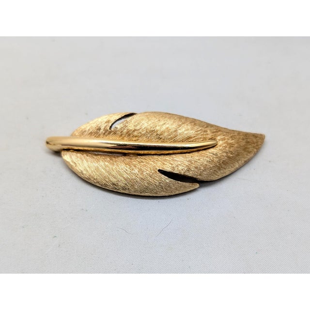 1980s goldtone textured leaf with smooth stem brooch with security clasp. Marked "GIVENCHY" twice inside a cartouche with...