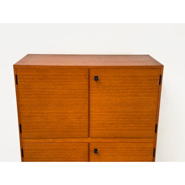 Timeless teak cabinet with four doors and original solid wood frame in a Scandinavian, minimalist design. The cabinet...