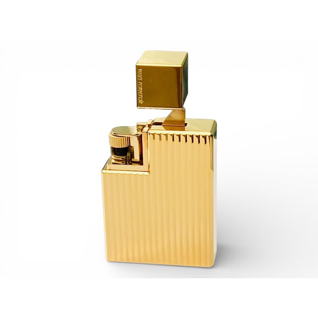 A refined Cartier pocket lighter executed in gold-plated metal with elegant engine-turned vertical decoration. The...