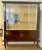 Art Deco display cabinet with two sliding glass doors, two glass shelves and beautiful brass elements: sphinxes, laurel...