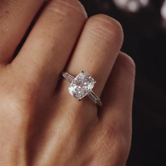 This exquisite Mid Century platinum ring features a dazzling 1.56 carat cushion brilliant cut diamond of exceptional E...