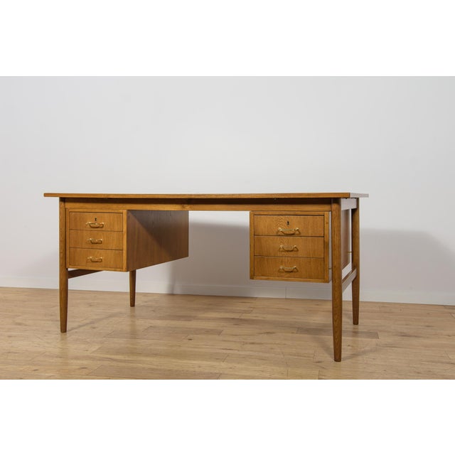 This oak executive desk was manufactured in Denmark during the 1960s. The piece represents the characteristic qualities of...