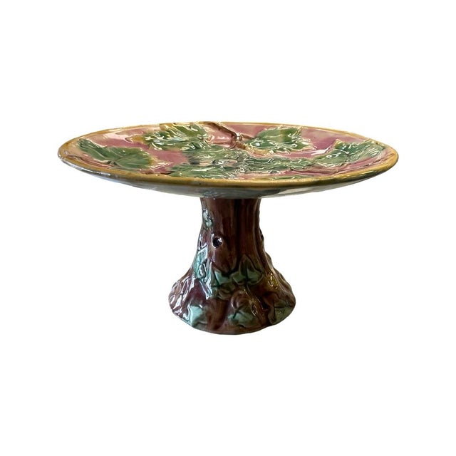 Early 20th Century Etruscan Majolica Cake Stand. Top is Round with a Pink Background Filled with Green, Yellow and Brown...