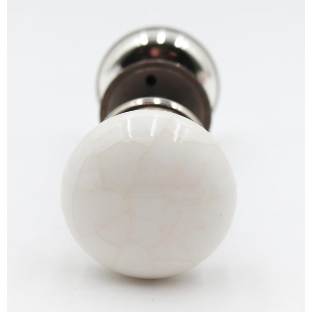 Unique antique passage door knob set featuring a white ceramic knob and a mercury glass knob. The rosettes have a nickel...